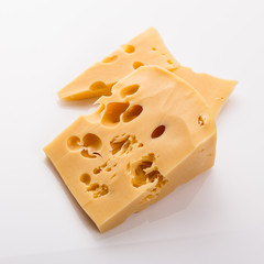 Piece and slices of cheese on a white background