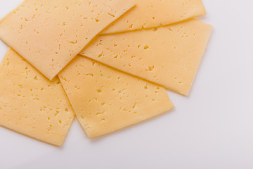 Piece and slices of cheese on a white background