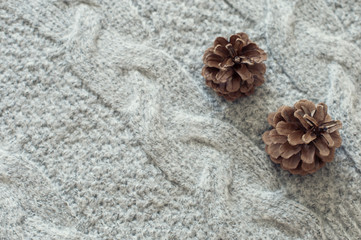Fototapeta na wymiar Knitting wool winter background with pine cones
