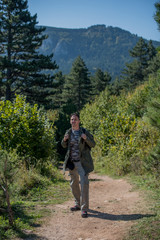 Obraz premium hiker on dirt road out of forest 