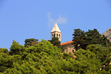 Fototapeta na wymiar Old church above small mediterranean town Brela , Croatia