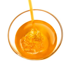 Honey pouring and glass jar isolated on white background. Organic bee products..