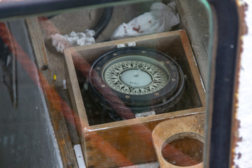 closeup of a compass through the window of a boat