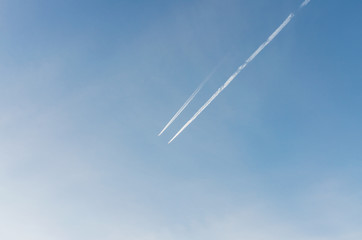 Contrails from an airplane against a blue sky