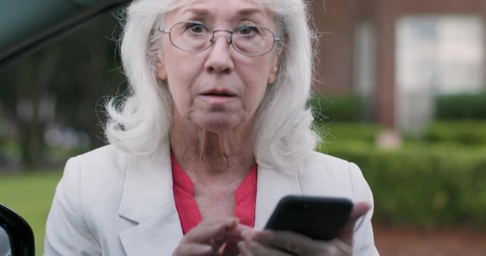 A retiree launching a second career as an Uber or Lyft driver checks the mobile app then greets her passenger and engages in friendly conversation before starting the ride.