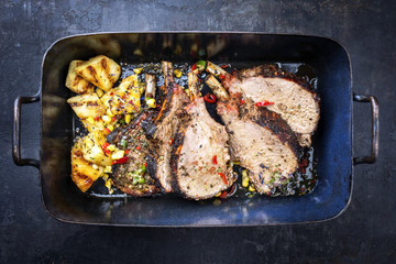 Exotically barbecue veal back racks carree roast with corn and pineapple as top view in a backing dish - obrazy, fototapety, plakaty