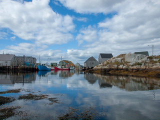 Obraz premium Peggy's Cove Harbour with boats at low tide, summer, clouds in blue sky, peaceful