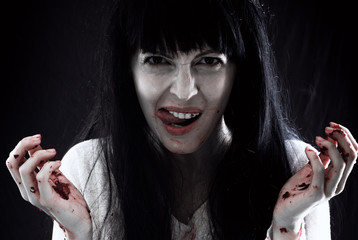 Crazy bloody scary zombie woman screams at camera