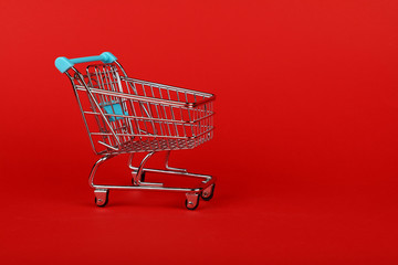 Close up retail shopping cart on red background