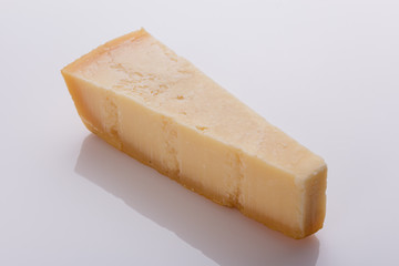 A fragrant parmesan piece on a white acrylic background