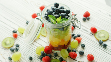 From above shot of jar filled with colorful mix of sweet fruit and berry mix and served on table