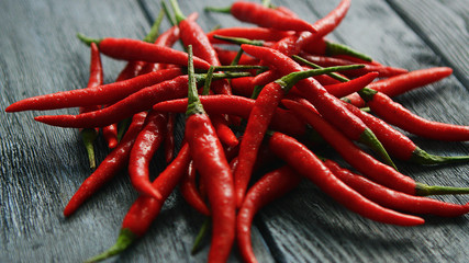 Closeup shot of bright red chili peppers composed in heap on wooden table surface