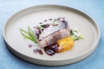 Modern style Japanese bonito tuna fish filet with vegetable and pineapple glazed in teriyaki sauce as closeup on a plate