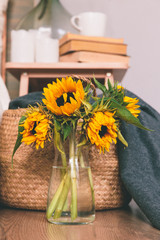 Yellow sunflowers in vase on floor of the room