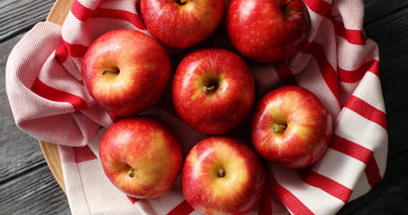 Flat lay of arranged red apples on clean napkin and reflecting daylight in shiny peel served on table