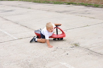 The boy fell, riding in a car