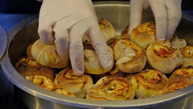 Close up waiter displays rolls with cheese and vegetables in a deep bowl.HD video .Slow motion.