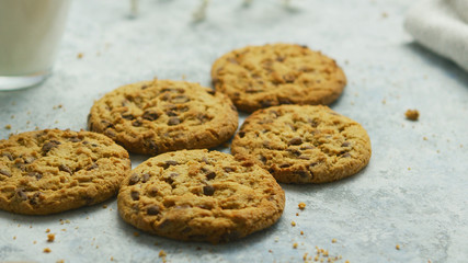 Closeup shot of sweet crunchy chocolate chip cookies lying on table with crumbles around