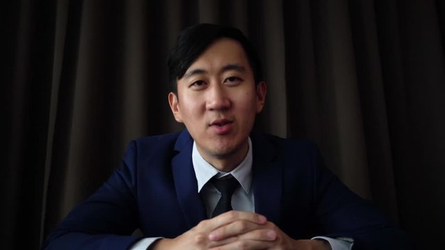 Young Asian business man speaking on the video call conference with happiness and good mood