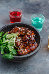 Spicy baked chicken wings in a bowl, dark background