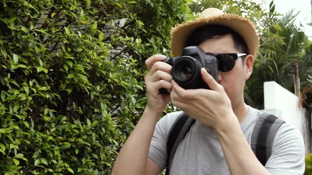 Orbit circle shot of young male travel photographer tourist taking photos in nature scenery