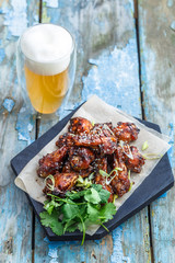 Buffalo chicken wings with beer, rustic background, copy space