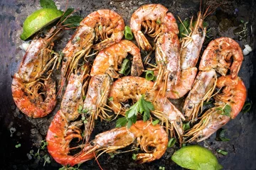 Rolgordijnen Traditional fried black tiger prawn with lemon as top view on a rustic old board © HLPhoto