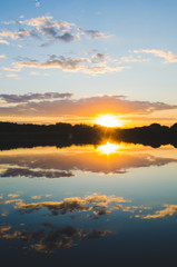 Quiet surface of the river on the background of a colorful sunset.Beautiful landscape of nature.