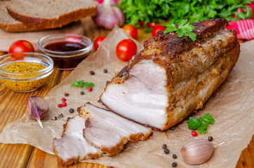Roast pork belly in mustard honey glaze on a dark wooden background. Rustic style.