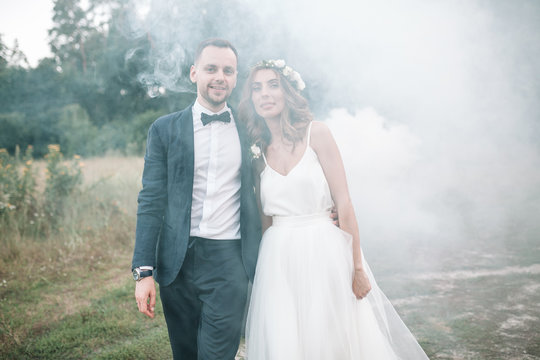 Beautiful bride and groom. Wedding ceremony in nature. Smoke bombs.