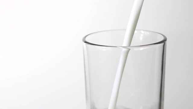 Pouring milk on white background, closeup