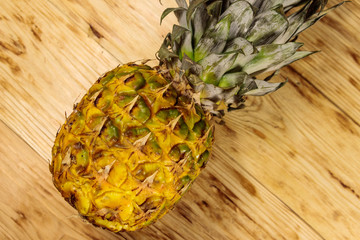 Whole pineapple on wooden table. Top view