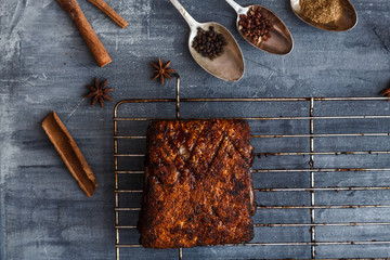 Chinese crispy skin pork belly on dark concrete background with spices, copy space