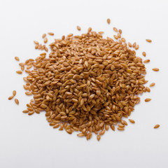 Seeds of golden flax on a white background