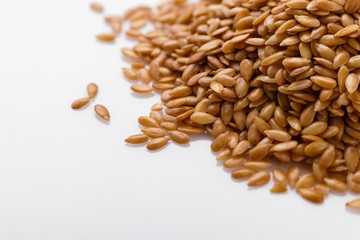 Seeds of golden flax on a white background