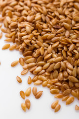 Seeds of golden flax on a white background