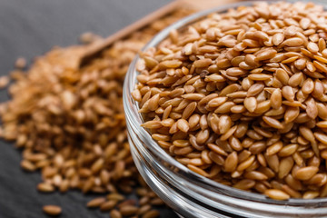 seeds of golden flax on a dark stone background