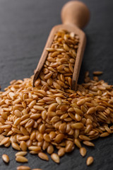 seeds of golden flax on a dark stone background
