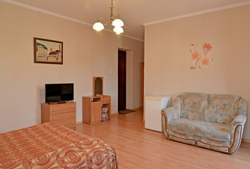 An interior of the hotel room in pink tones with a picture on a wall. Modern classics