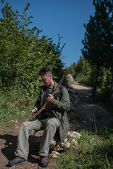 hiker making stick from old branch