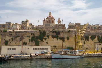Fototapeta na wymiar A sailing boat moored at the fortified City of Senglea, Malta.