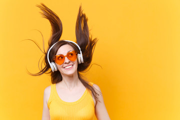 Portrait of excited cheerful laughter funny comic woman in orange glasses in headphones with...