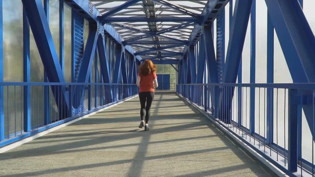 red-haired athletic woman passionate about Jogging in urban environment,slow motion