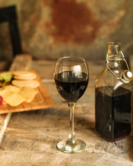 glass of red wine and a bottle on the table (alcohol). Top view. food background copy space