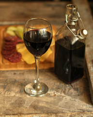 glass of red wine and a bottle on the table (alcohol). Top view. food background copy space