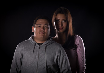 studio portrait of a guy and a girl on a black background