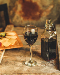glass of red wine and a bottle on the table (alcohol). Top view. food background copy space