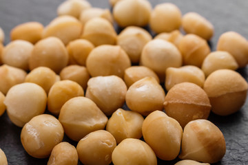 delicious macadamia nuts on a dark stone background