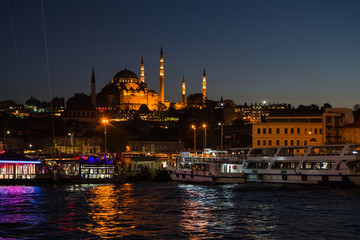 Fototapeta na wymiar Evening view of the Golden Horn Bay with the Eminonu Pier on the background of the Suleymaniye Mosque.