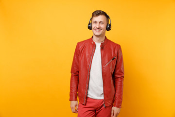 Portrait vogue happy fun young man in red leather jacket, t-shirt listen music in headphones...